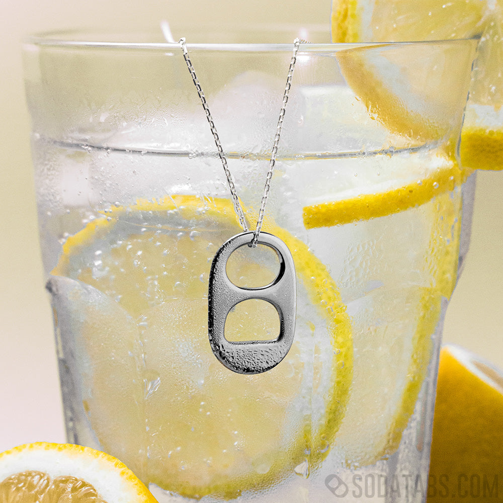 Up close photo of a wet Soda Tab Pendant hanging from a cup of lemonade 