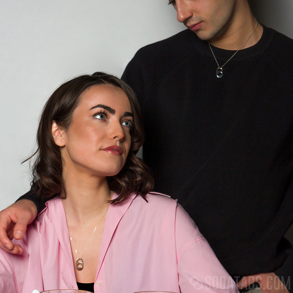 Male and female models wearing matching silver Soda Tab charms on silver chains